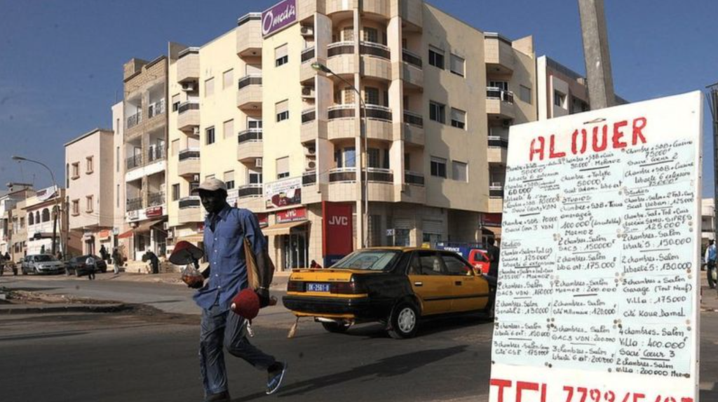 une affiche indiquant "A louer" devant un immeuble vide dans un quartier résidentiel de Dakar.